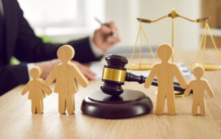 Gavel and family figures on judge's table illustrating concept of divorce and child custody